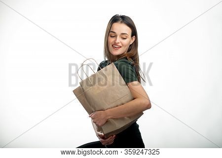 Beautiful Youngwoman Holding Grocery Shopping Bag. White Background. Young Girl With Bag Under Arm. 