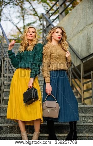 Sweater Skirt Trend. Matching Outfits. Women Sisters Outdoors Stairs Background. Matching Colors. Pe