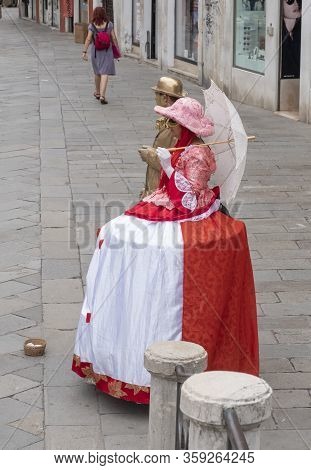 Venice, Italy - June 30, 2017: Two People In Woman Red Venetian Clothes, Man In Goldcolored Clothes 