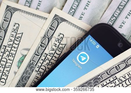 Smartphone Screen With Telegram App And Lot Of Hundred Dollar Bills. Business And Social Networking 