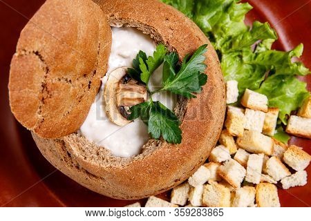 Mushroom Cream Soup In A Bowl Of Bread With Crackers On A Brown Plate
