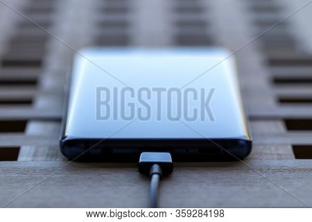 Brecht, Belgium - April 1 2020: A Close Up Portrait Of A Smartphone With A Usb Cable In Its Port. It