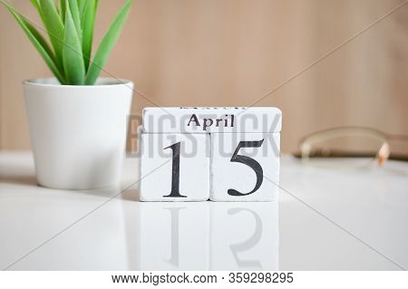 Date On White Wooden Cubes - The Fifteenth, 15 April On A White Table. Close Up.