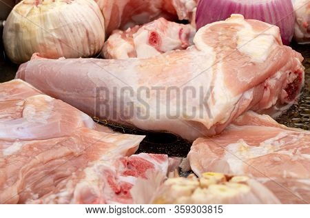 Raw Meat Of Suckling Lamb (suckling Lamb). Prepared On A Roasting Tray (with Garlic And Red Onion).
