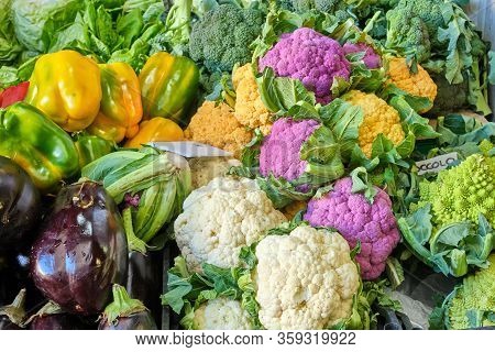 Differrent Kinds Of Colorful Caulifower And Other Vegetables For Sale At A Market