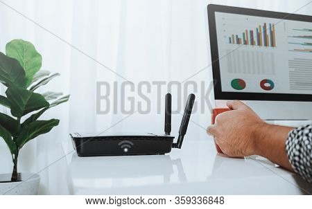 Closeup Of A Wireless Router And A Man Using Computer On Living Room At Home Ofiice, Man Working Fro