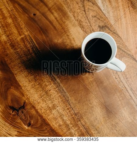 A White Cup Of Cofee On Wooden Table.