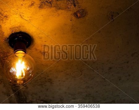 An Electric Lamp Shines On A Brown Background On The Ceiling.
