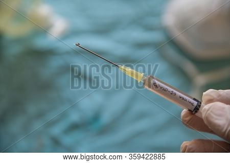 Close Up Shot Of A Syringe With The Word Coronavirus Vaccine.the Hand Holding It Is Pressing The Plu