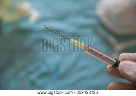 Close Up Shot Of A Syringe With The Word Coronavirus Vaccine.the Hand Holding It Is Pressing The Plu