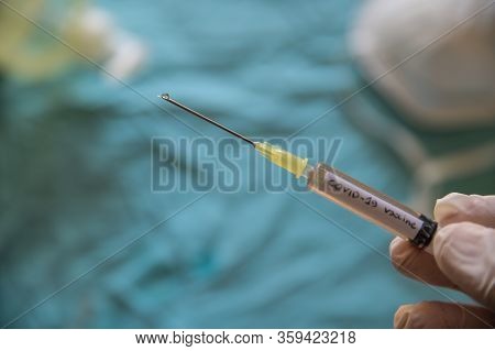 Close Up Shot Of A Syringe With The Word Coronavirus Vaccine.the Hand Holding It Is Pressing The Plu