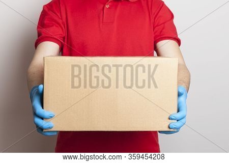 Contactless Delivery Of Products And Goods During Quarantine. Online Order. Male Delivery Man In Uni