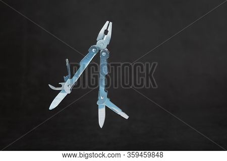 Multi-functional Tool Flying On A Black Background. The Concept Of An Extended Multi-tool With Free 