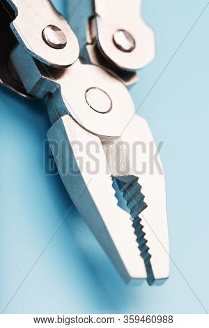 The Multitool Multi-function Tool Hovers On A Blue Background. The Concept Of An Expanded Multi-tool