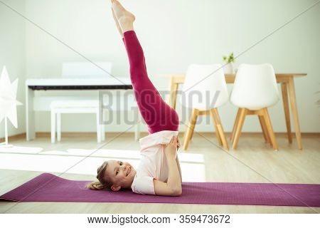 Pretty Happy Child Girl Having Fun Making Yoga Exercises At Home During Coronavirus Quarantine