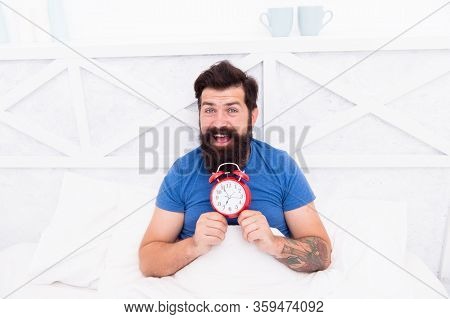 Happy Wake Up Of Man Lying In Bed With Alarm Clock. Guy Is Waking Up. Alarm Clock In The Morning. Ma