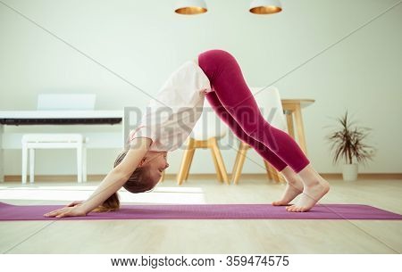 Pretty Happy Child Girl Having Fun Making Yoga Exercises At Home During Coronavirus Quarantine
