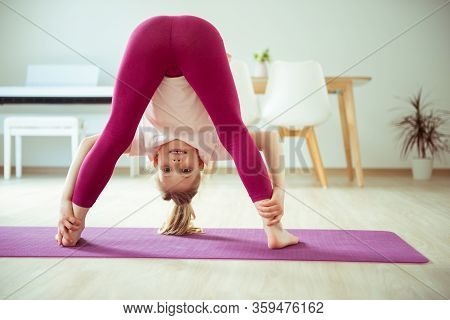 Pretty Happy Child Girl Having Fun Making Yoga Exercises At Home During Coronavirus Quarantine