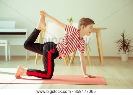 Teen Boy Doing Yoga Exercises At Home Due To Coronavirus Quarantine