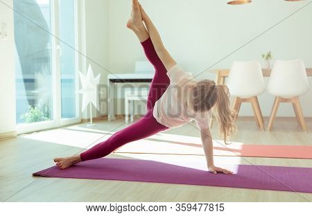 Pretty Happy Child Girl Having Fun Making Yoga Exercises At Home During Coronavirus Quarantine