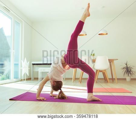 Pretty Happy Child Girl Having Fun Making Yoga Exercises At Home During Coronavirus Quarantine
