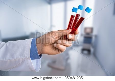 Young Doctor With A Stethoscope Shows Tube With Blood Or Plant On Pastel Gradien Background