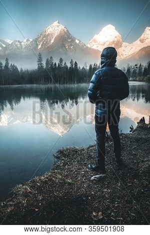 Male Hiker Standing At Mountain Lake Schiederweiher Watching The Sunrise In Austria