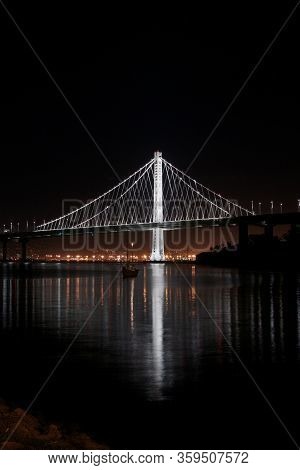 Long Exposure Photo Of The New East Span Bay Bridge Illuminated  At Night, Reflecting Glowing Lights