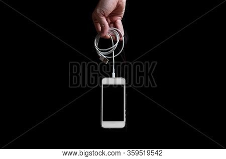Man Holding Smartphone With Empty Screen Isolated On Black Background. Male Hands With Phone, Space 