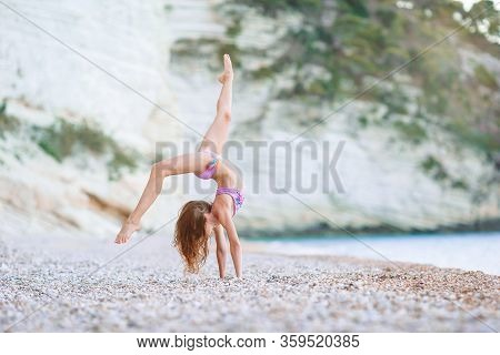 Adorable Active Little Girl At Beach During Summer Vacation