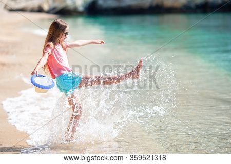 Adorable Active Little Girl At Beach During Summer Vacation