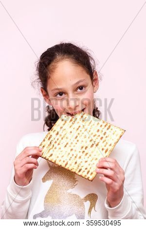 Portrait Of The Cute Teenager Girl Holding Matzah. Jewish Child Eating Matzo Unleavened Bread In Jew