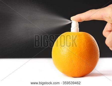 Hand Presses On Fresh Orange Dispenser On White Table On Black Background, Concept Of Natural Cosmet