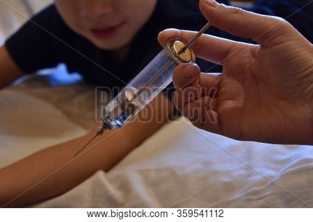 The Boy Is Afraid Of Injections. The Pediatrician With A Syringe. Baby Medical Syringe. Compulsory T