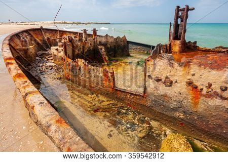 View Of A Rusty Shipwreck On The Beach. Habonim Shore, Israel