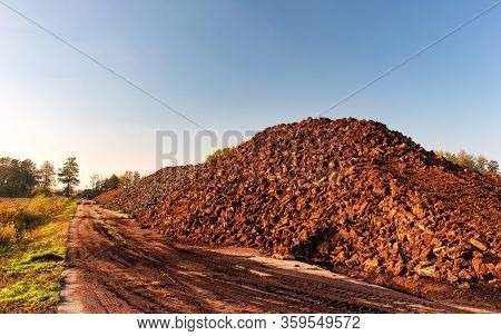 Cutted Peat Was Piled Up In A Heap After Drying. It Will Be Grounded, Packed And Then Sold As Garden