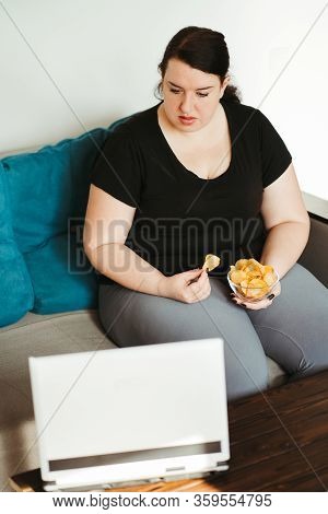 Mindless Snacking, Home Sedentary Lifestyle, Compulsive Overeating. Obese Lazy Woman Sitting On Sofa