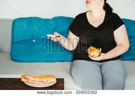 Mindless Snacking, Home Sedentary Lifestyle, Compulsive Overeating. Obese Lazy Woman Sitting On Sofa