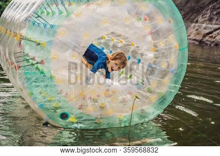 Cute Little Boy, Playing In Zorb A Rolling Plastic Cylinder Ring With A Hole In The Middle On The La