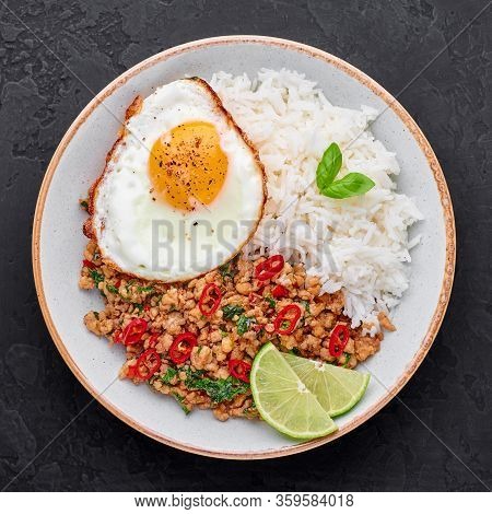 Pad Krapow Gai - Thai Basil Chicken With Rice And Fried Egg Black Slate Background. Pad Krapow Is Th