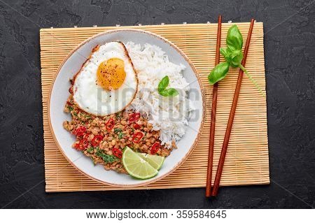 Pad Krapow Gai - Thai Basil Chicken With Rice And Fried Egg Black Slate Background. Pad Krapow Is Th