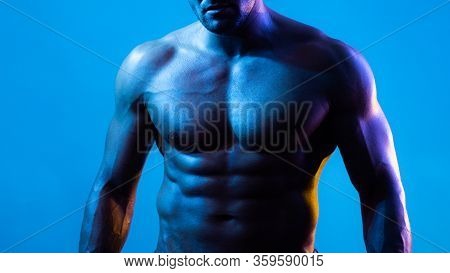 Muscular Model Sports Young Man On Blue Dark Background. Fashion Portrait Of Strong Brutal Guy With 