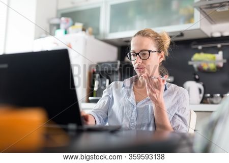 Stay At Home And Social Distancing. Woman In Her Casual Home Clothing Working Remotly From Kitchen D