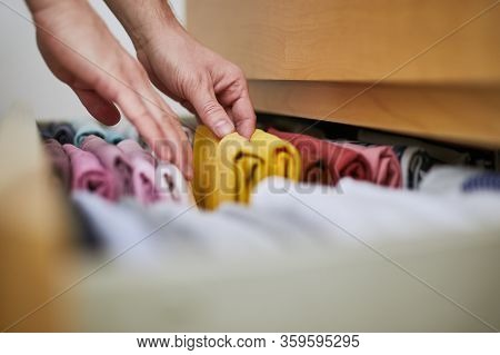 Organizing And Cleaning Home. Man Preparing Orderly Folded T-shirts In Drawer.