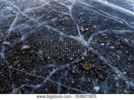 Natural Ice Background With Transparent Ice With Cracked And Icebound Stones