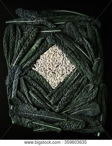 Green Tuskan Kale Leaves End Raw White Beans On A Dark Background. Healthy Detox Vegetables . Clean 
