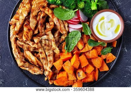 Skinny Grilled Chicken Breast And Vegetables Of Baked Sweet Potato,  Boiled Broccoli On A Black Plat