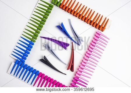 Frame Of Multi-colored Hair Clips On A White Background, In The Center Of The Hair Clips Are Large