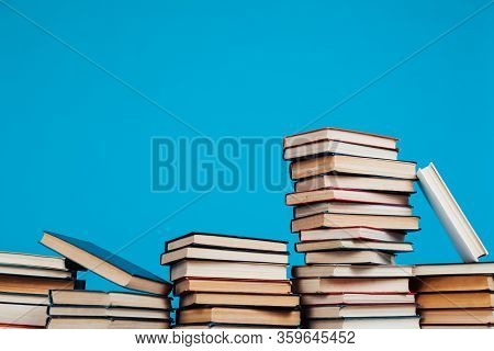 Many Stacks Of Educational Books For Learning Preparation For College Exams On A Blue Background