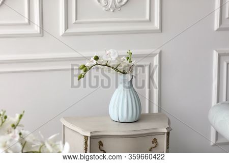 White Orchid Flowers In Vase On Table. Vintage Vase With Orchid At Home On Chest Of Drawers.